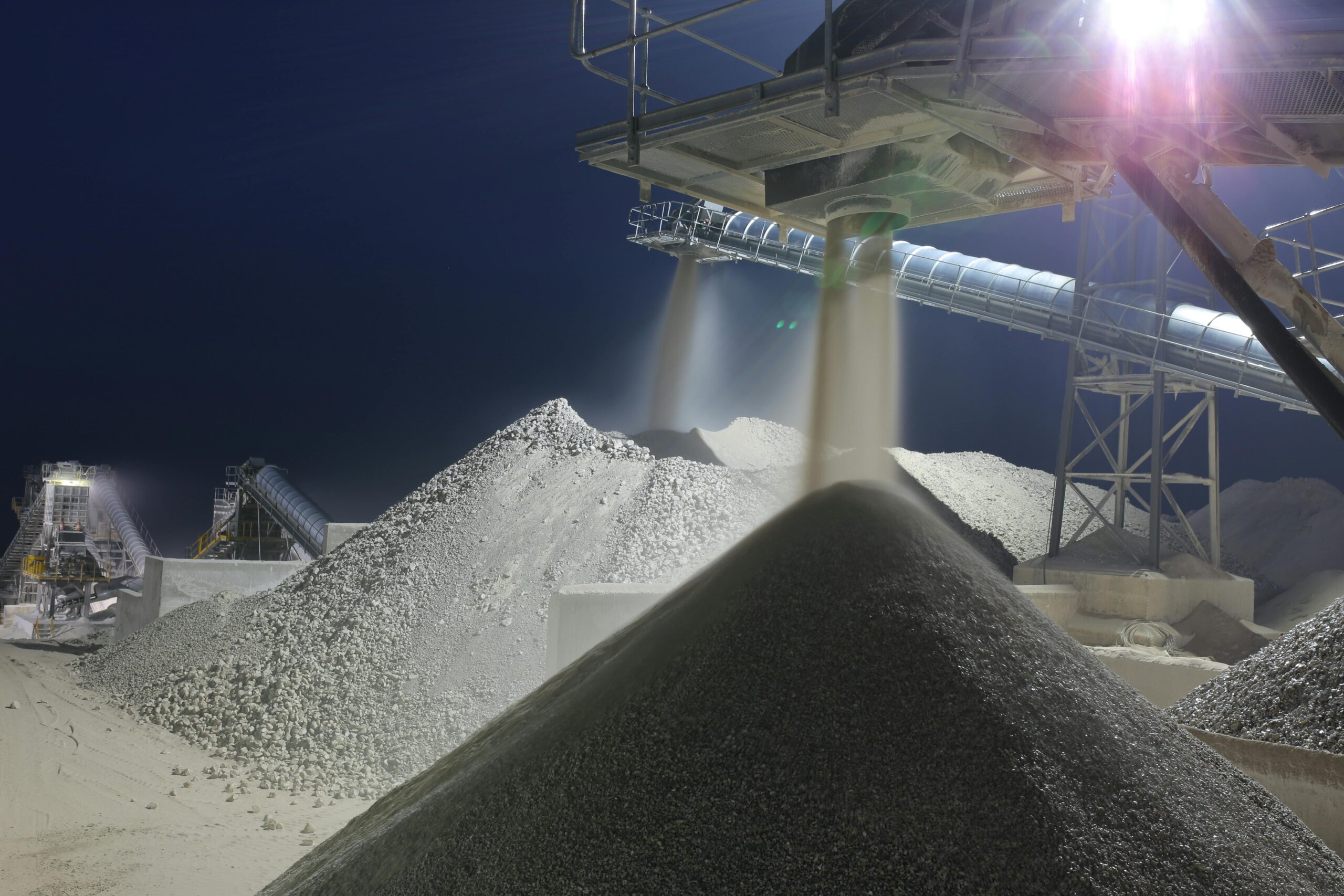 Nighttime industrial sand processing site in Ankara, Turkey with machinery and heaps of sand.